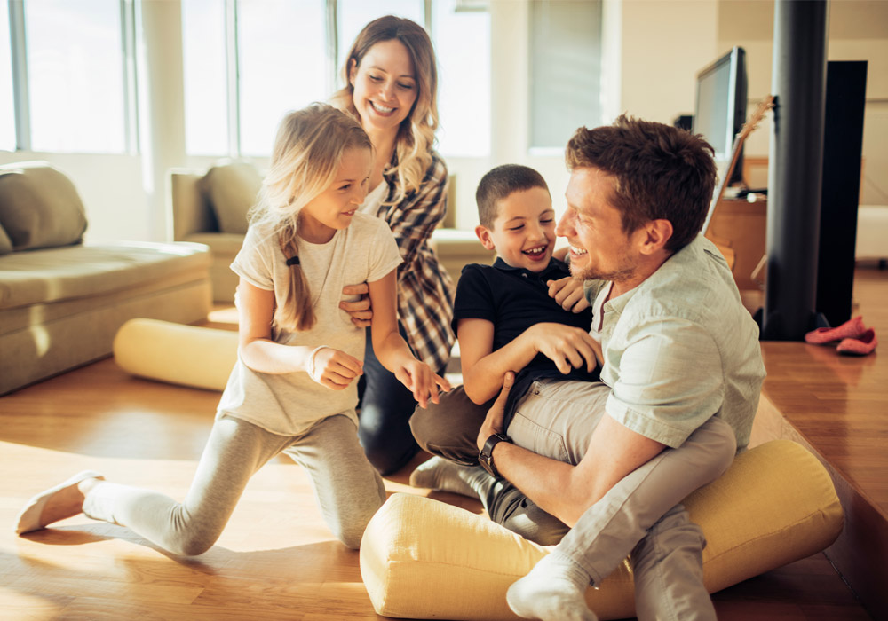 Glückliche Familie ist im Wohnzimmer am toben