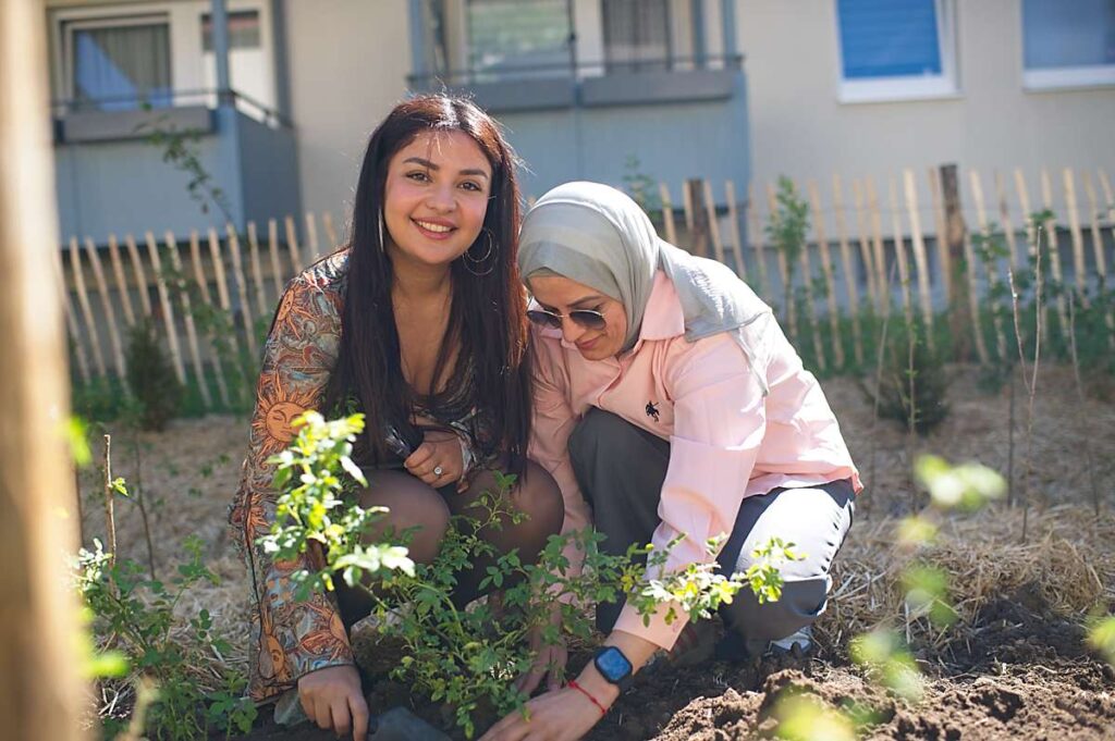 Zwei Frauen pflanzen einen Baum