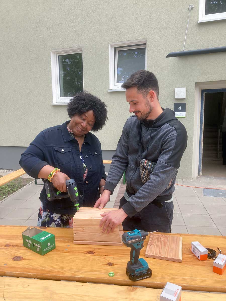 Zwei Personen bauen ein Vogelhaus